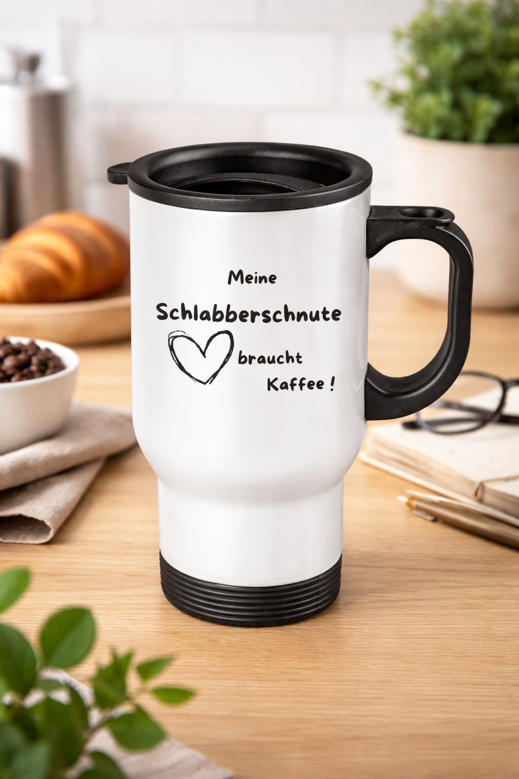 Weißer Edelstahl Thermobecher mit Spruch „Meine Schlabberschnute braucht Kaffee“ auf Holztisch mit Kaffeezubehör